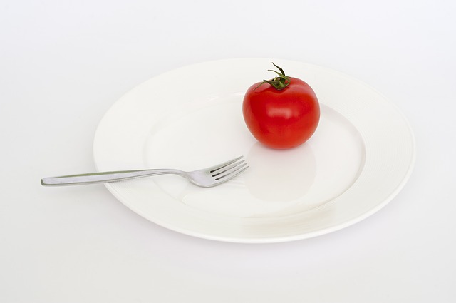 prázdný talíř, rajče a vidlička